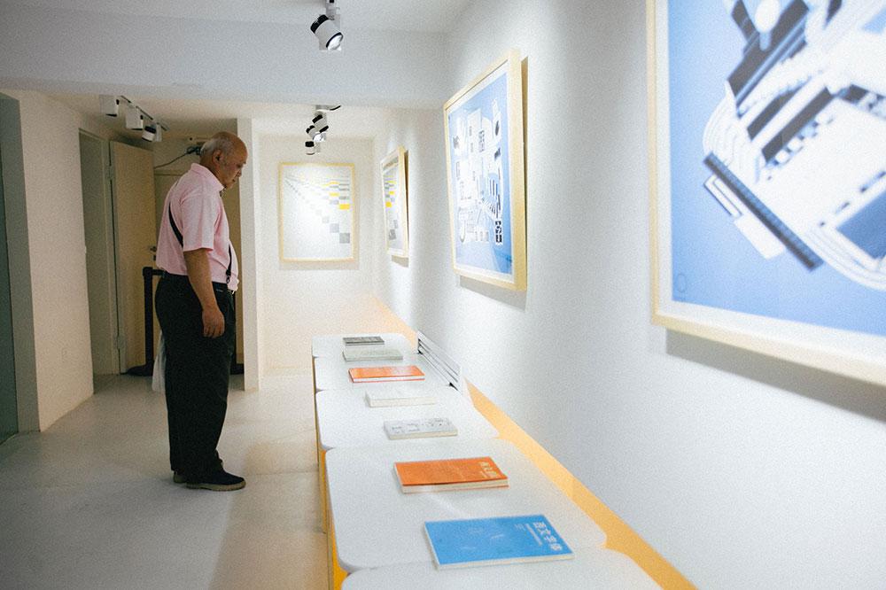 陈其瑞先生在二层展厅观看 TIB 成员的出版物及十周年纪念海报